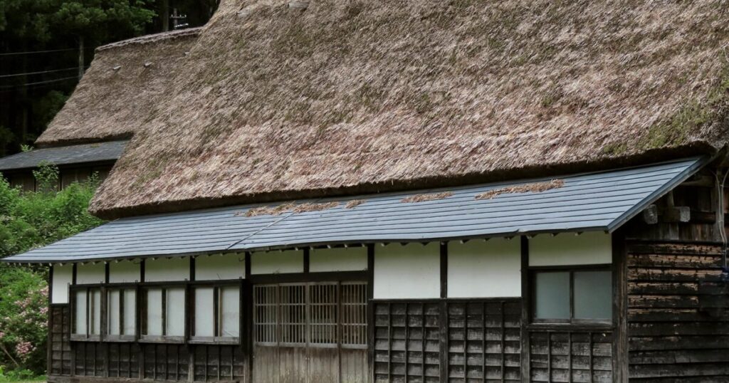 茅葺き屋根の古民家と緑の風景