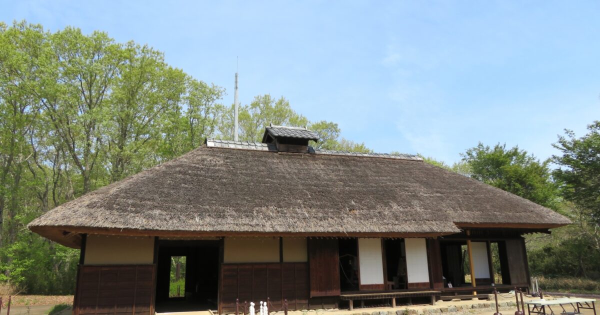 茅葺き屋根の古民家と青空